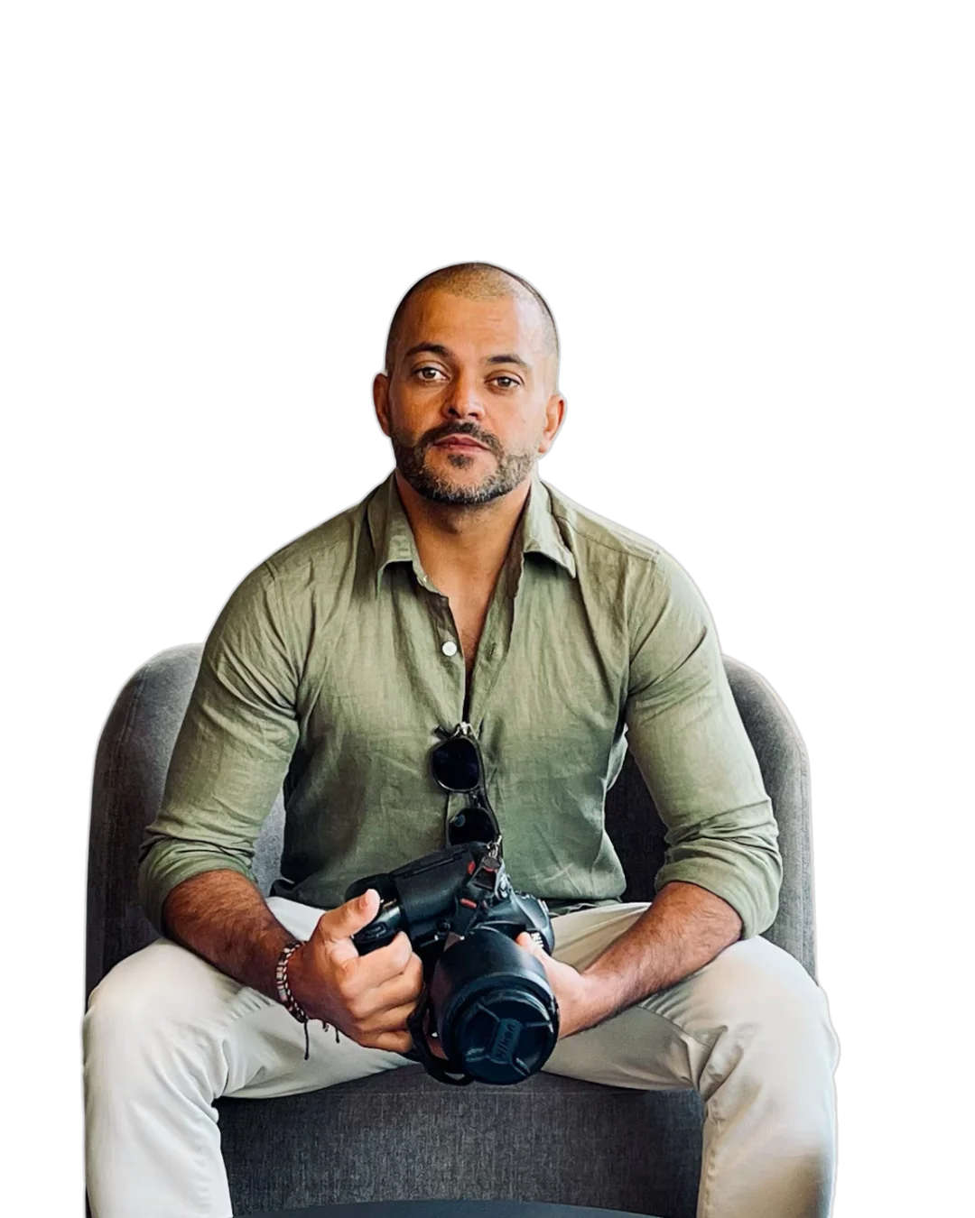 Tiago de Souza, fotógrafo, sentado segurando uma câmera